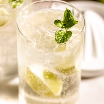 tequila and sprite in highball glass with lemon and mint