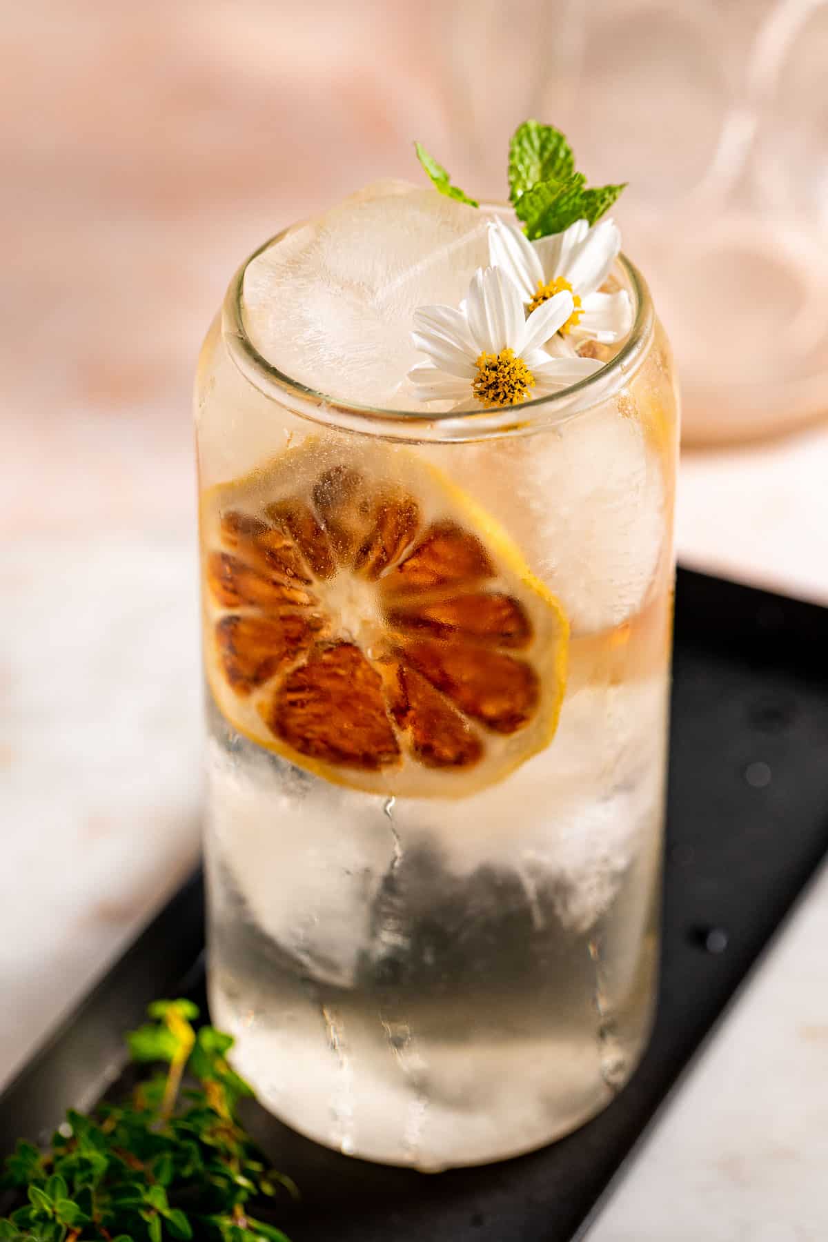 A cocktail served with ice and edible flowers