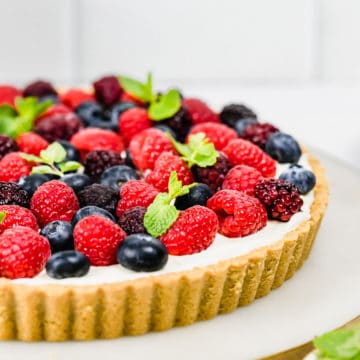 Berry tart with fresh raspberries, blueberries and mint