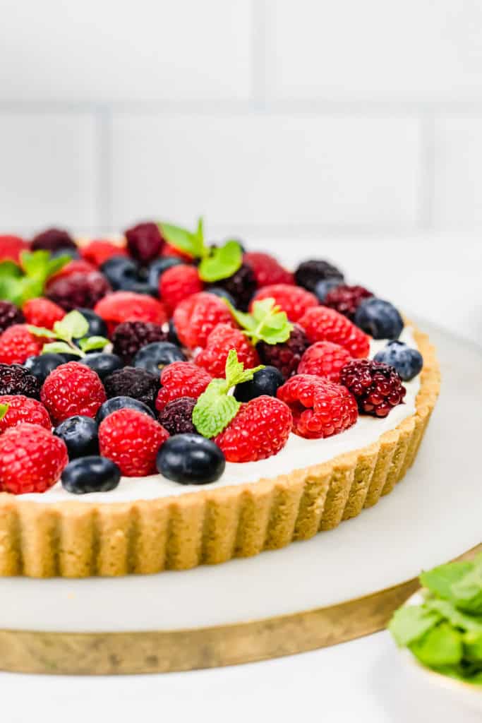 Berry tart with fresh raspberries, blueberries and mint