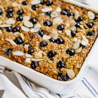 Lemon blueberry baked oatmeal in a white ceramic baking dish sitting on a counter.