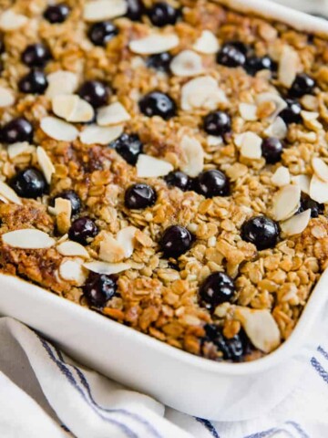 Lemon blueberry baked oatmeal in a white ceramic baking dish sitting on a counter.