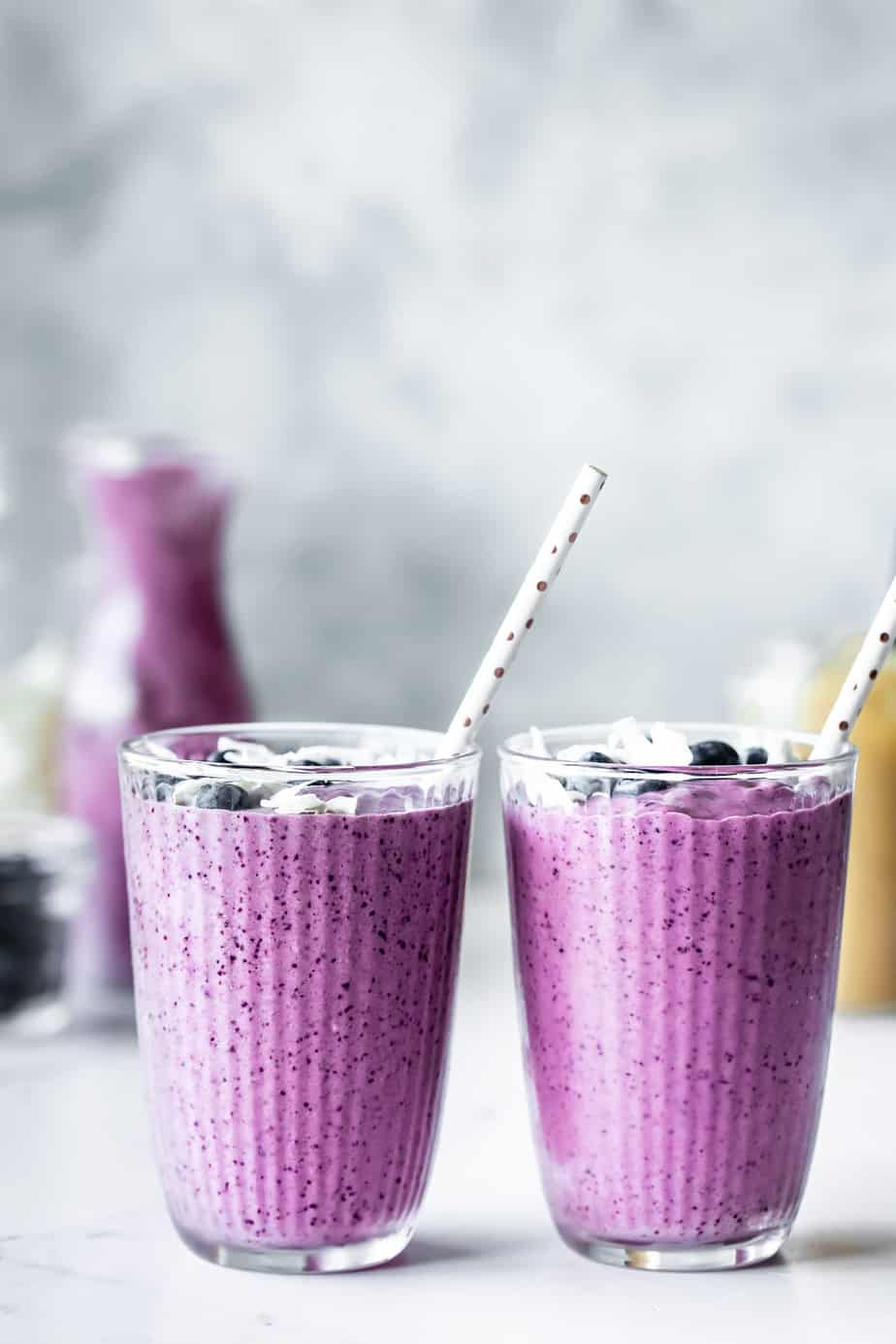blueberry pineapple smoothies in glasses with straws