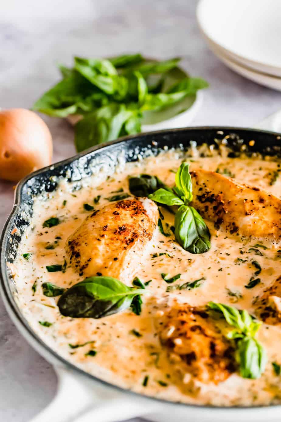 creamy tuscan garlic chicken in white skillet is what to serve with Fettuccine Alfredo