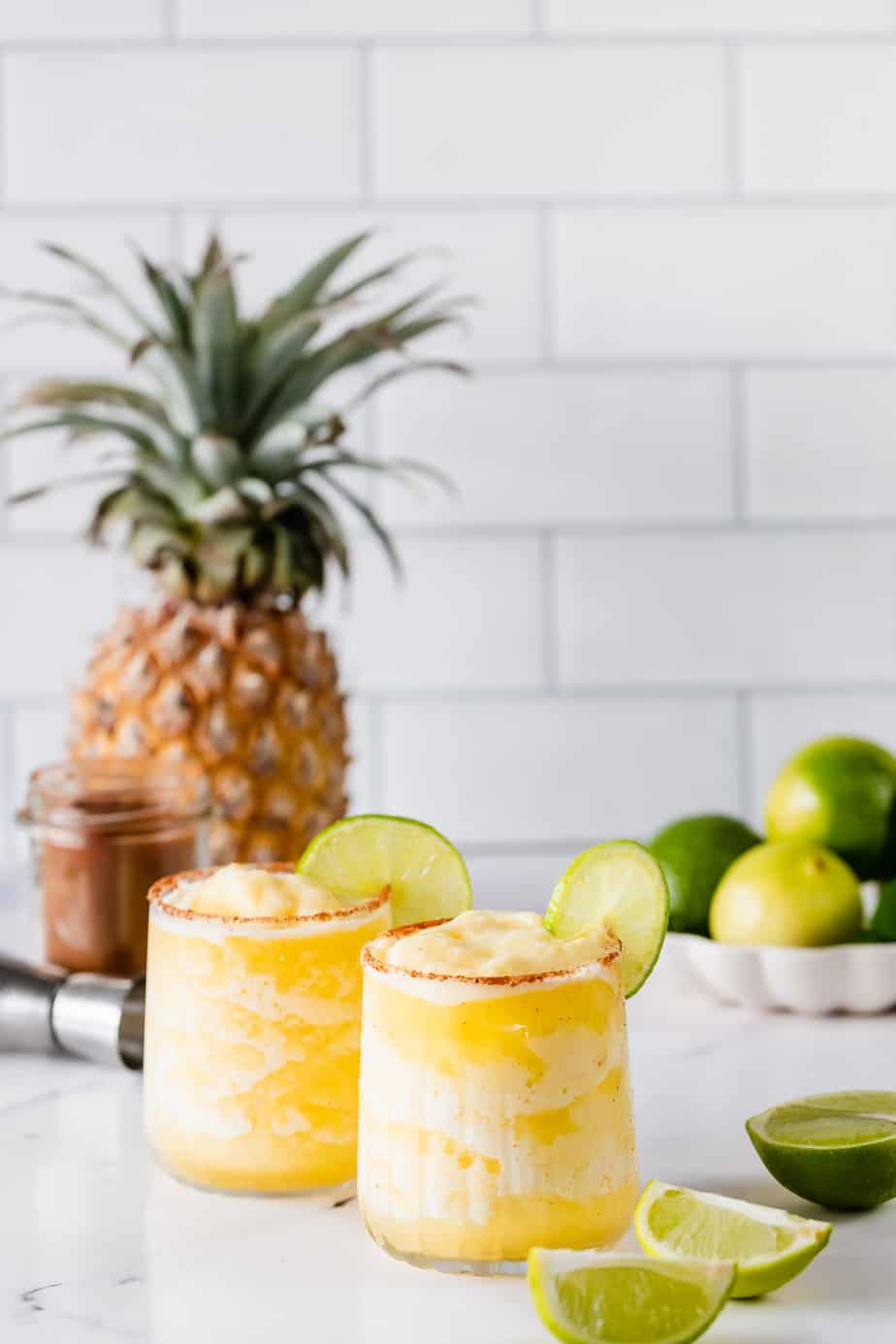 Frozen spicy pineapple margarita with pineapple in background