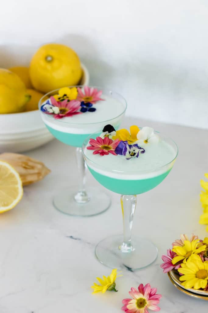 two blue mocktails with flowers