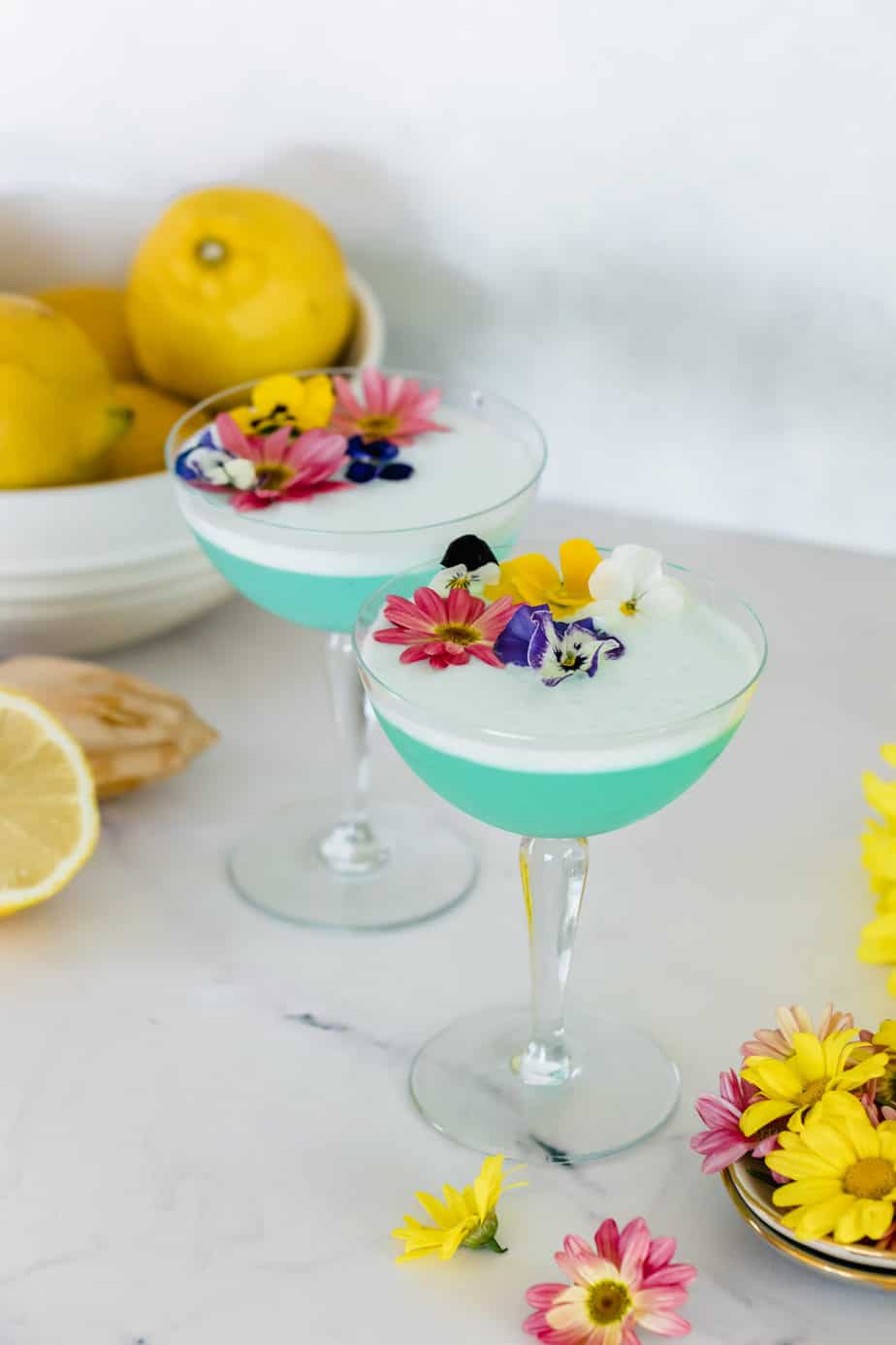 A Blueberry Gin Sour topped with fresh flowers.