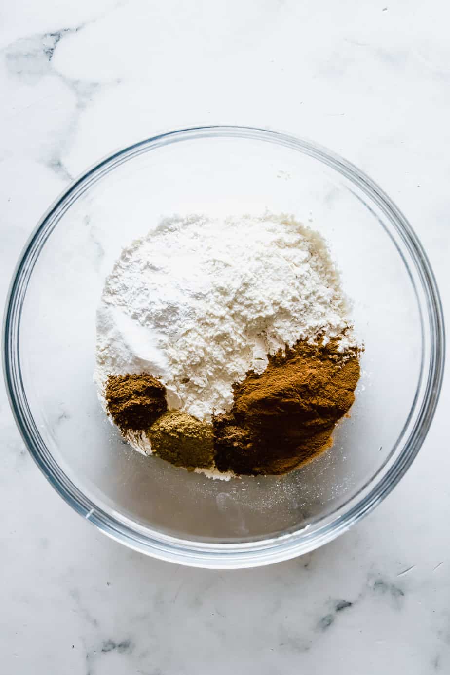 A glass bowl with dry ingredients.