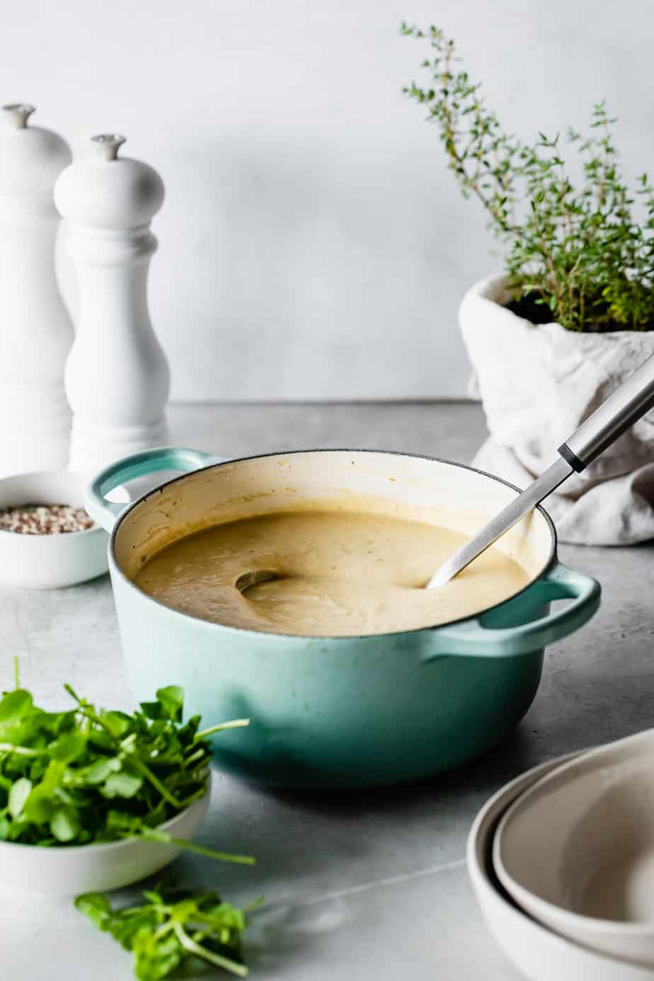 A pot full of Roasted Cauliflower Soup with a ladel.