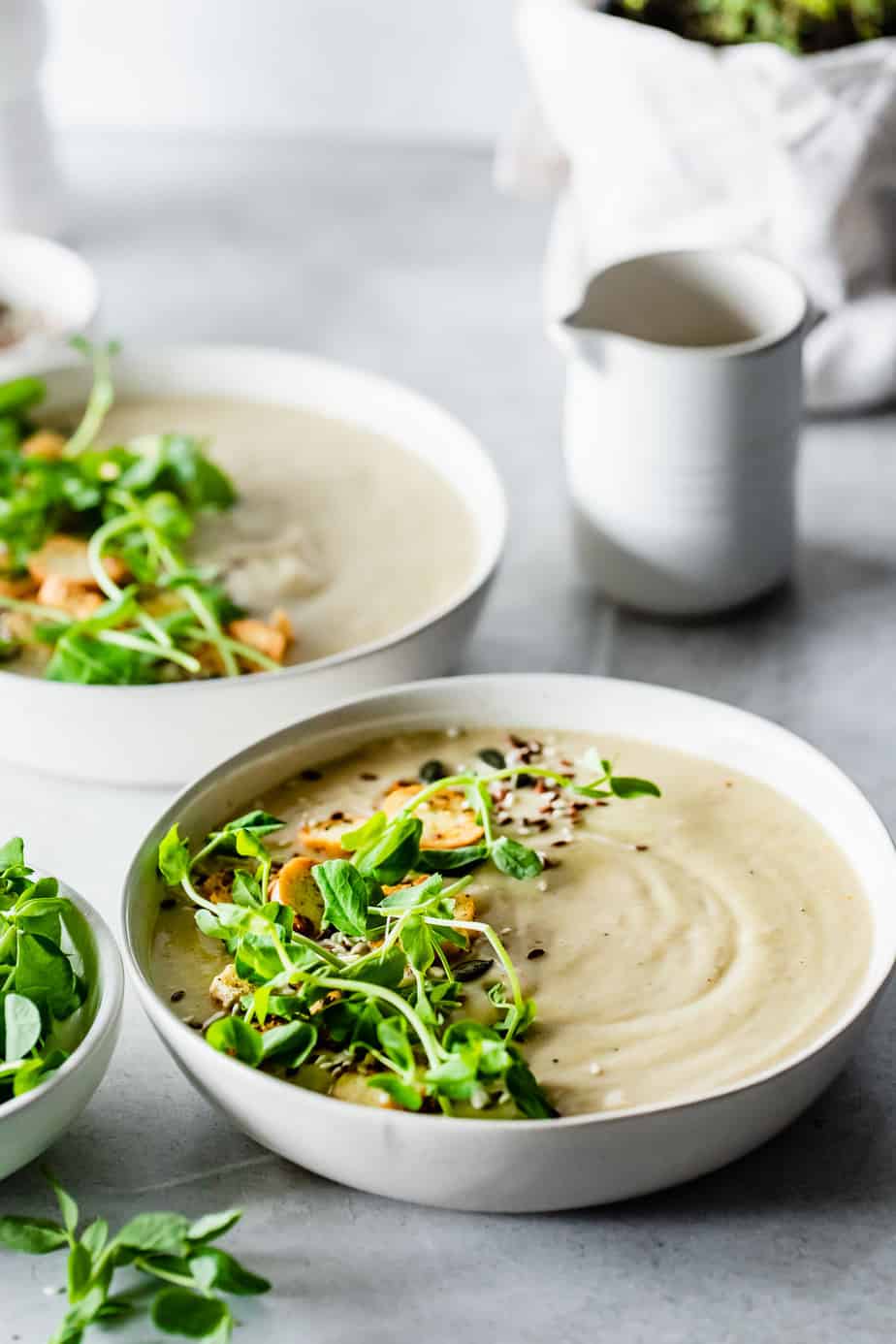 Creamy Roasted Cauliflower Soup with fresh herbs and seeds.