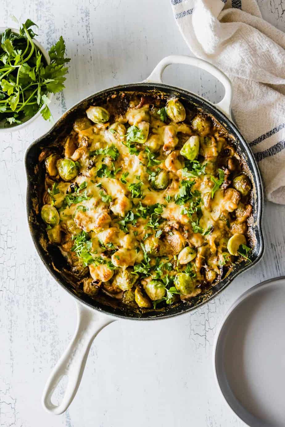 Cheesy brussels sprouts in a black skillet.