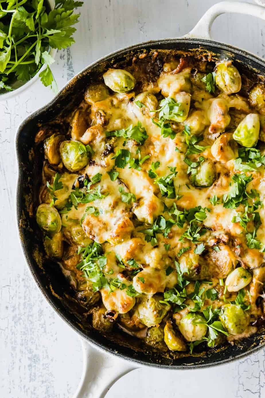 Cheesy brussels sprouts in a black skillet.