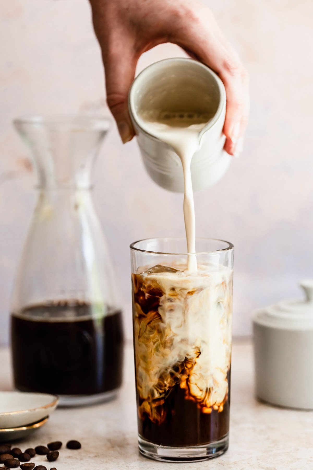 milk pouring into a glass with coffee