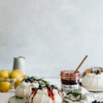 Pavlova with fresh berries and jam on marble board