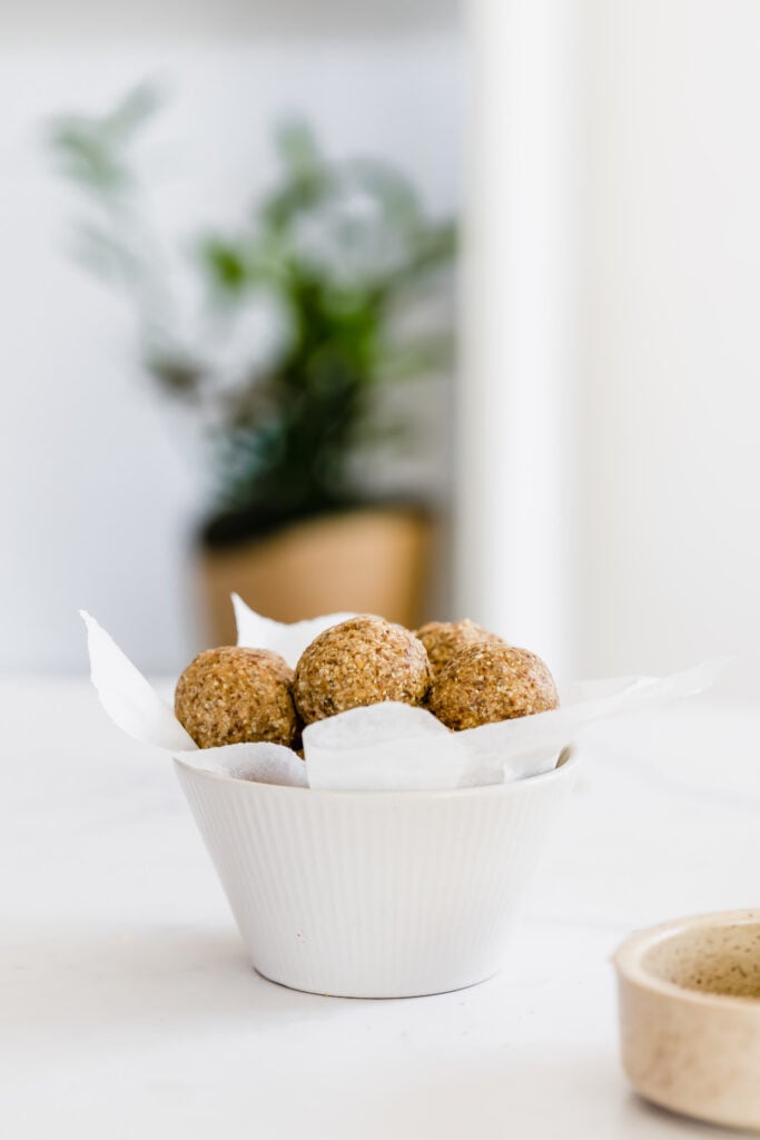 A small, white bowl filled with protein balls.