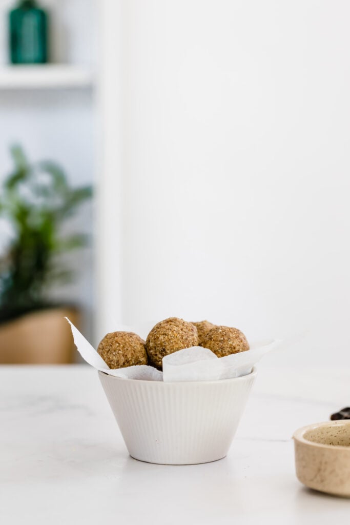 A small, white bowl filled with protein balls.