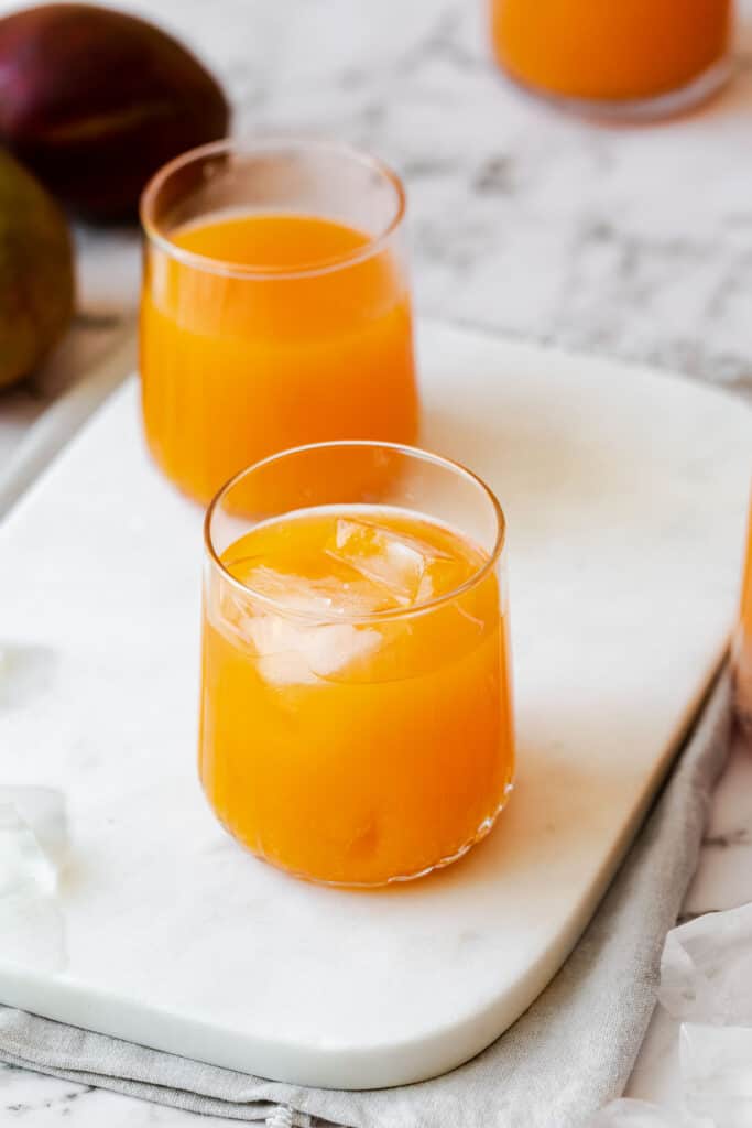two glasses filled with carrot mango juice