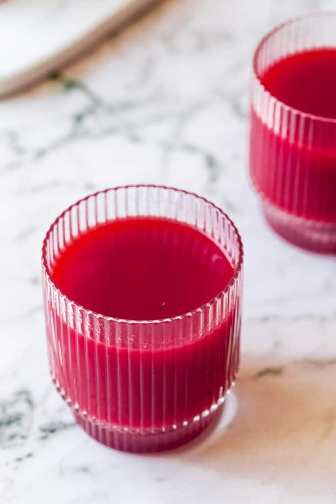 carrot and beet juice in glasses on marble