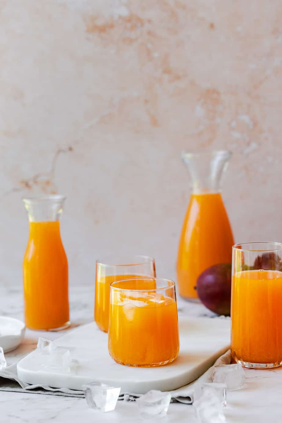 carrot mango juice in glasses and glass jugs