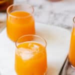 carrot mango juice in glasses on marble