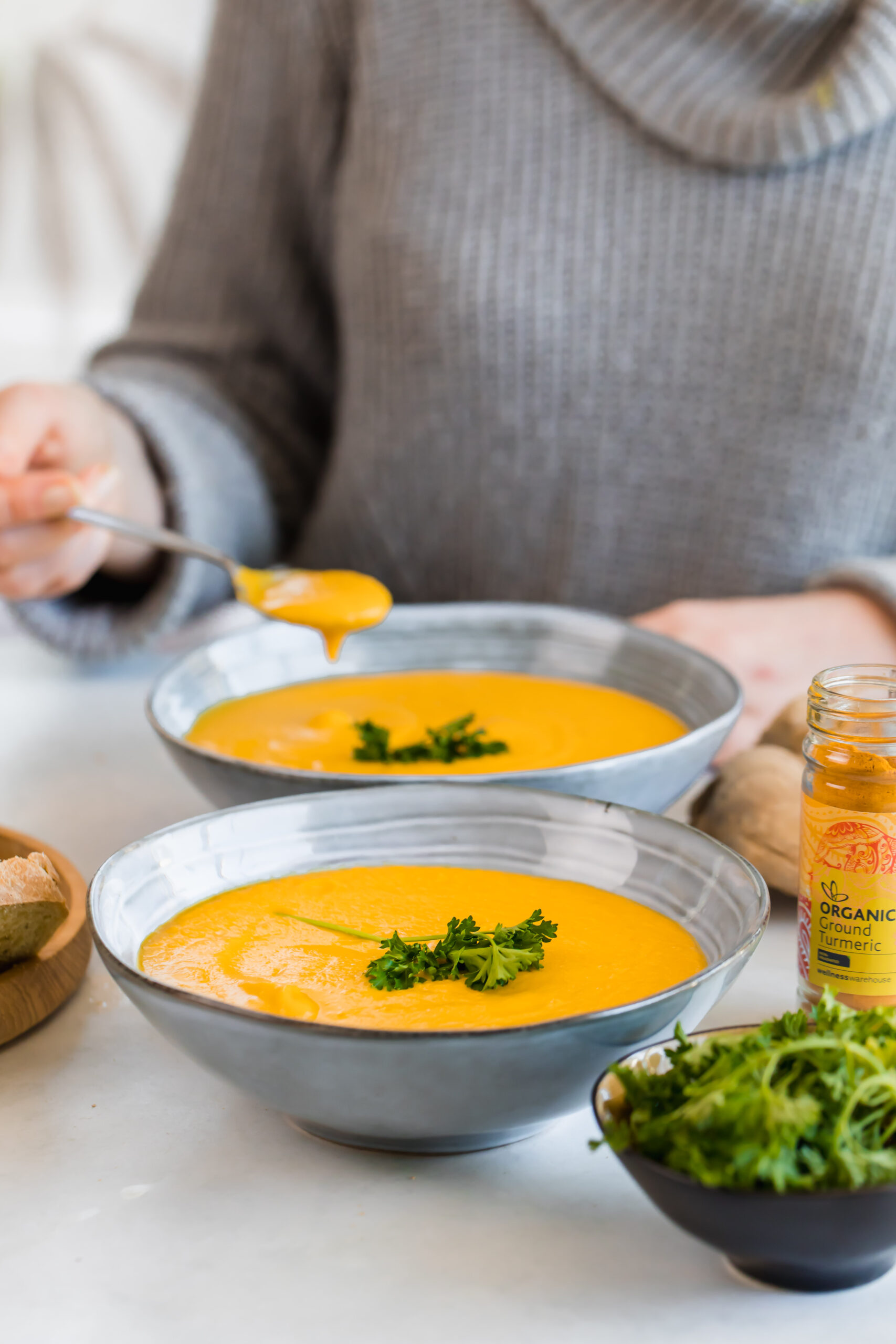 roast carrot and butternut soup in blue bowls with fresh herb