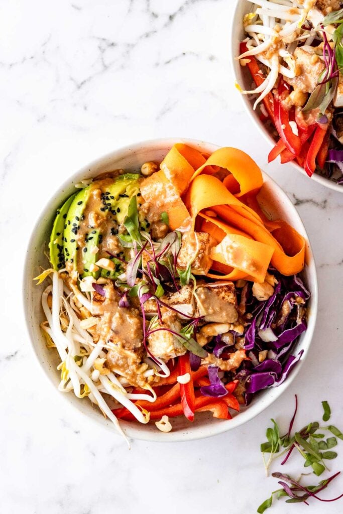 dragon bowls with avocado, carrots and sesame seeds on marble
