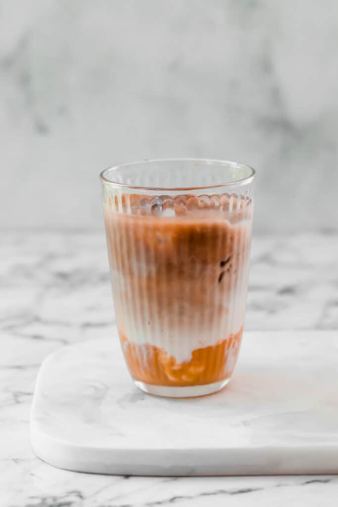 caramel mocha with ice in glass on marble board