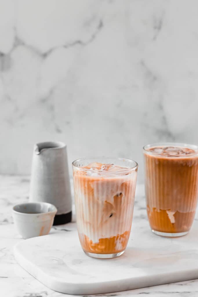 caramel mocha iced latte on marble board with small jug in background