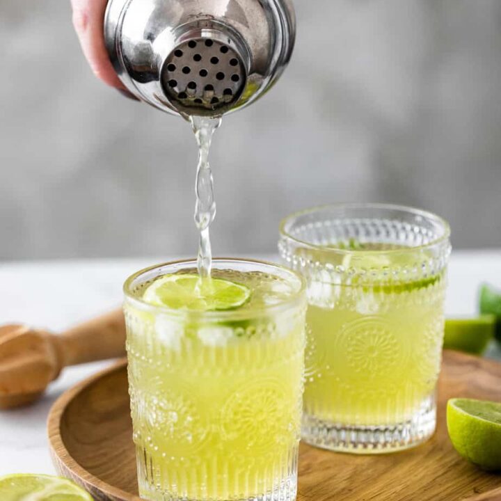 japanese iced tea in two glasses on wood with silver cocktail shaker