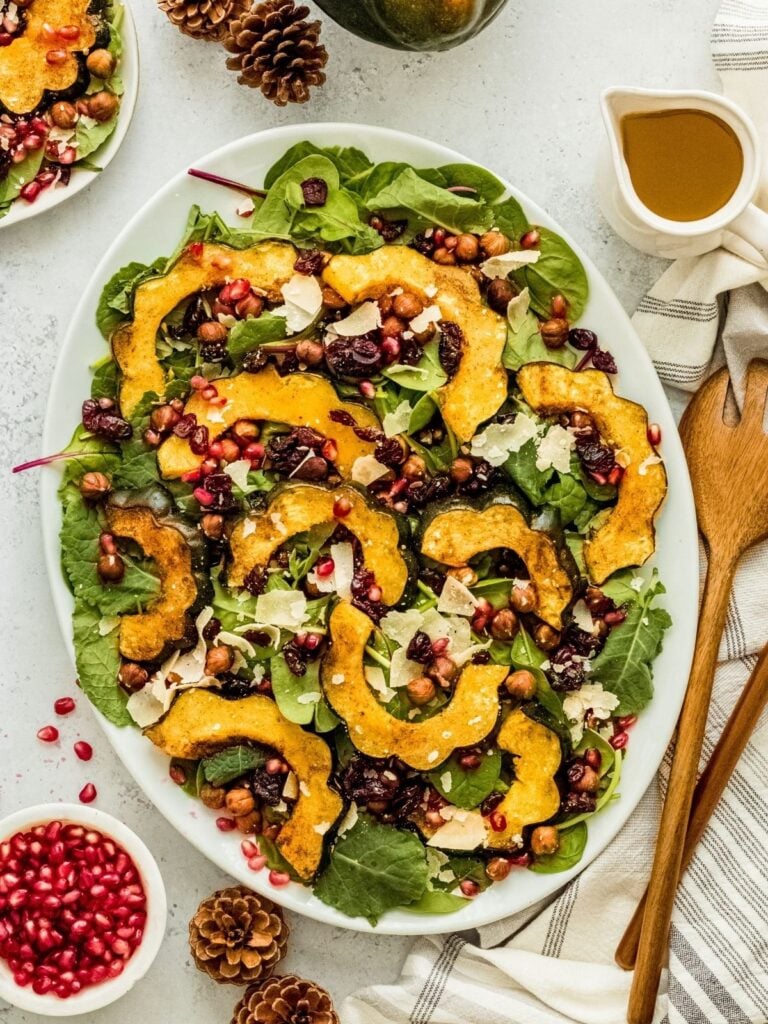 salad with squash and pomegranate seeds served on white plate