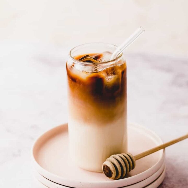 honey almond milk cold brew coffee in tall glass on pink plates
