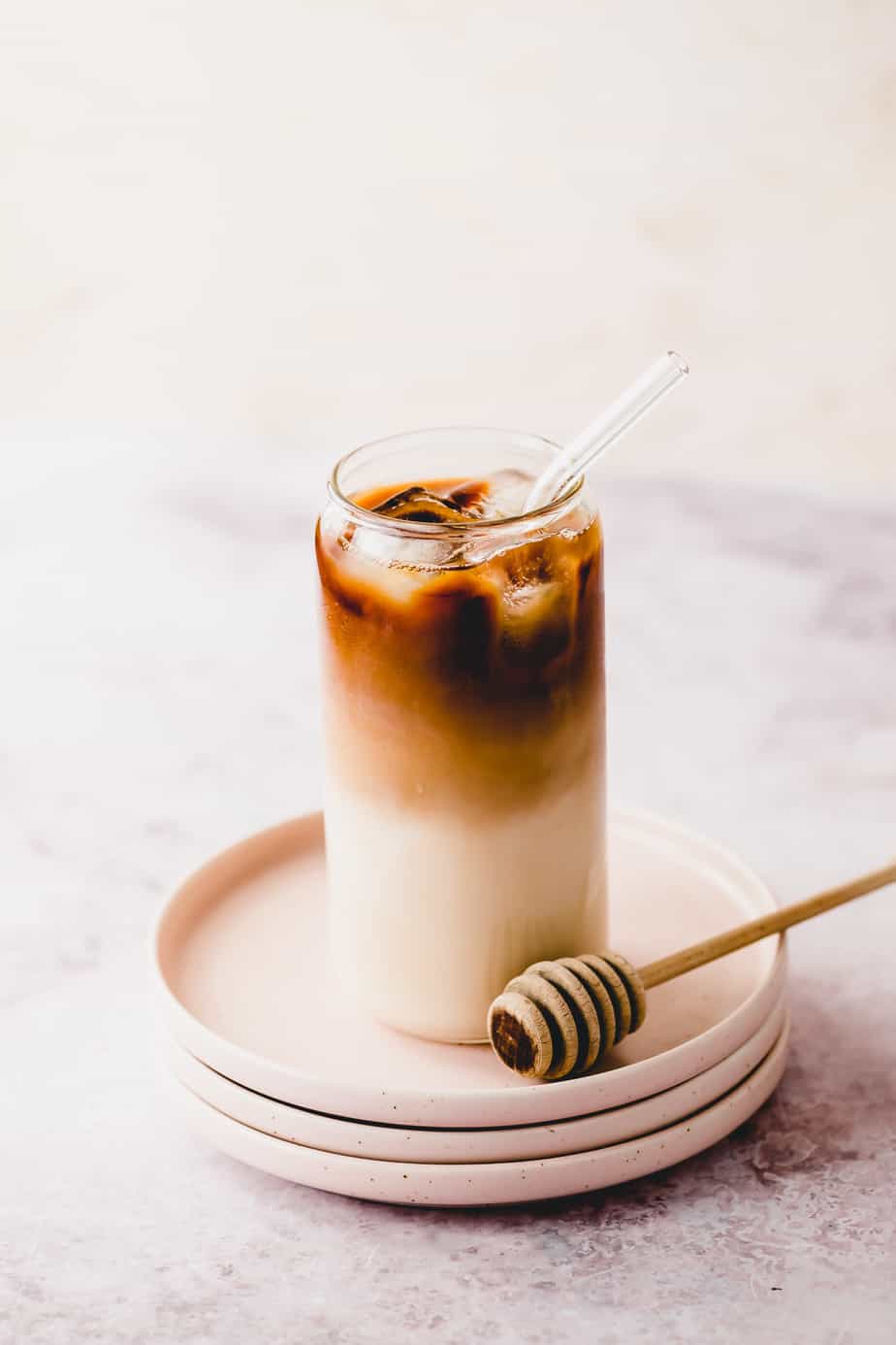 honey almond milk cold brew coffee in tall glass on pink plates