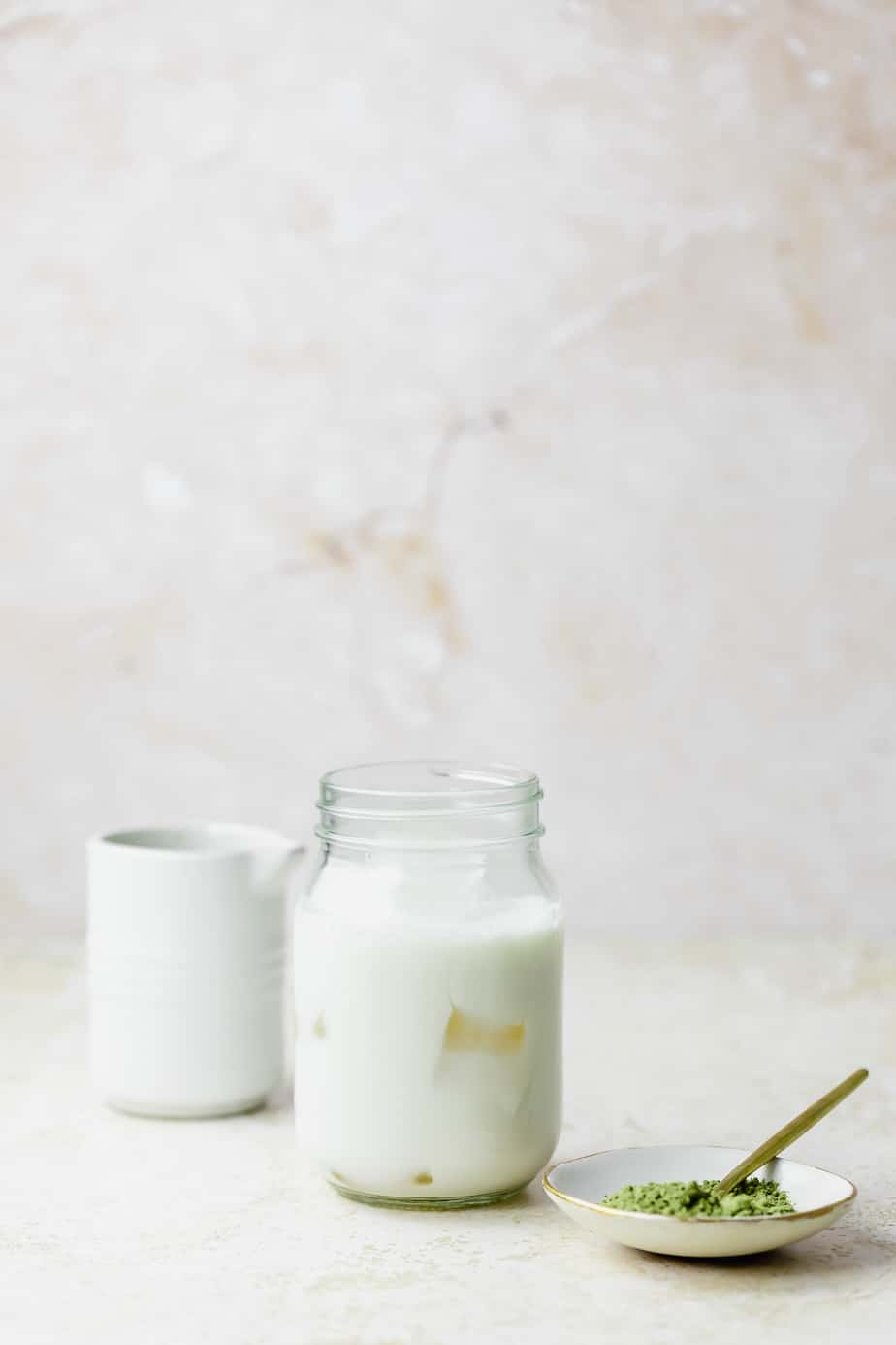 A jar of half and half with a white jug.
