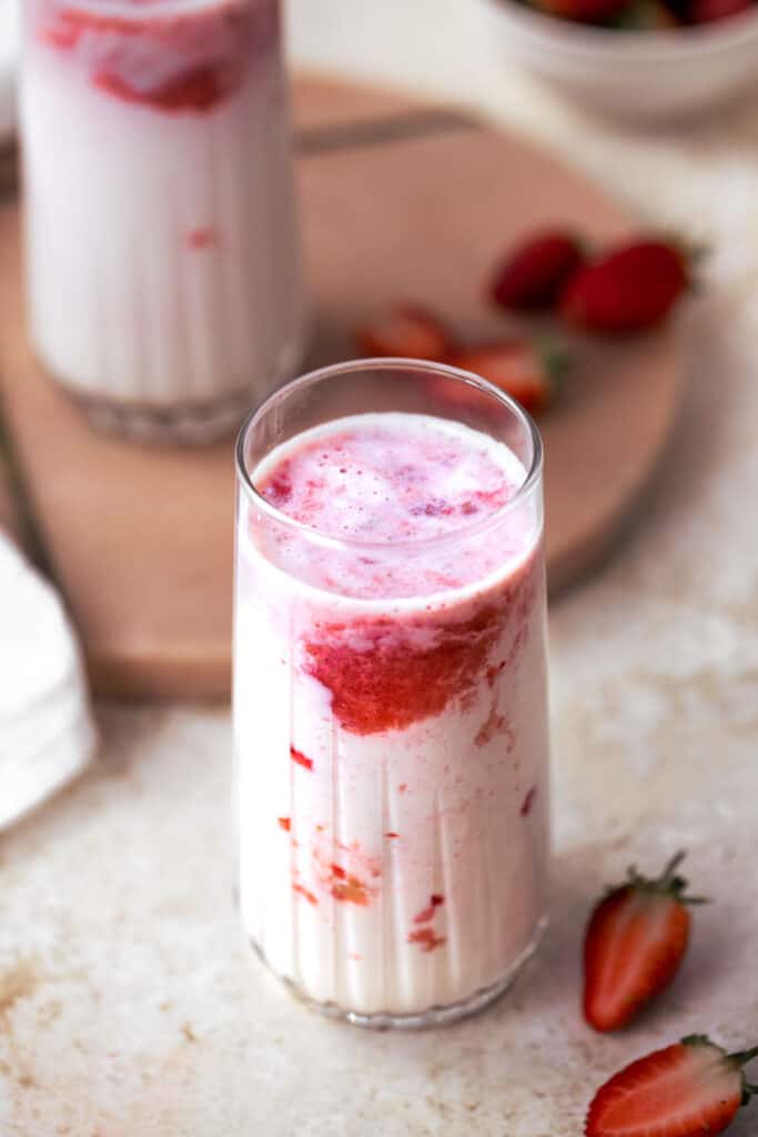 korean strawberry milk in tall glass with fresh strawberries