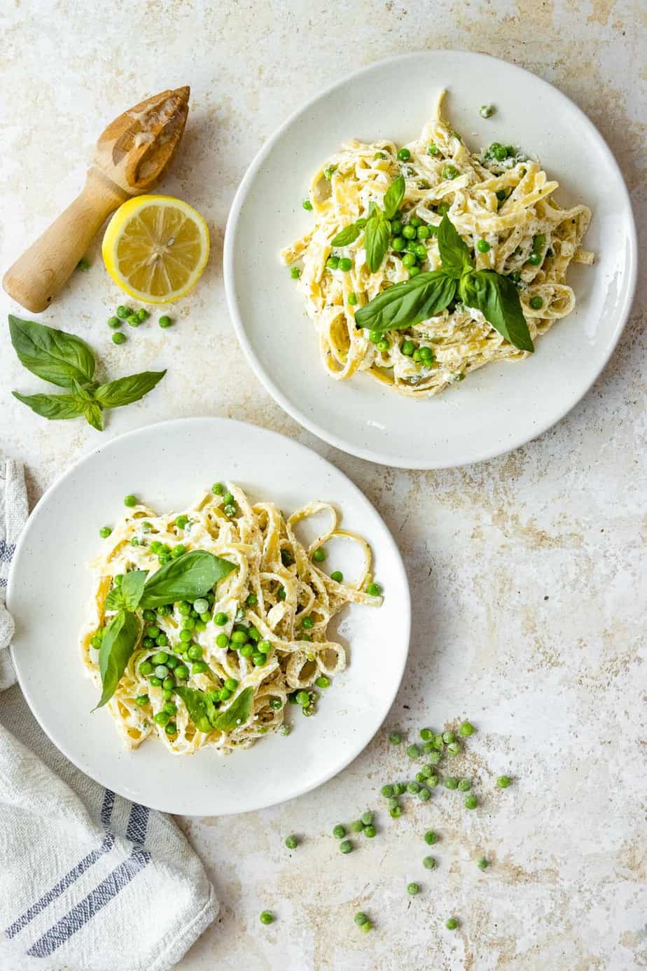 Pasta in bowls with peas and basil.