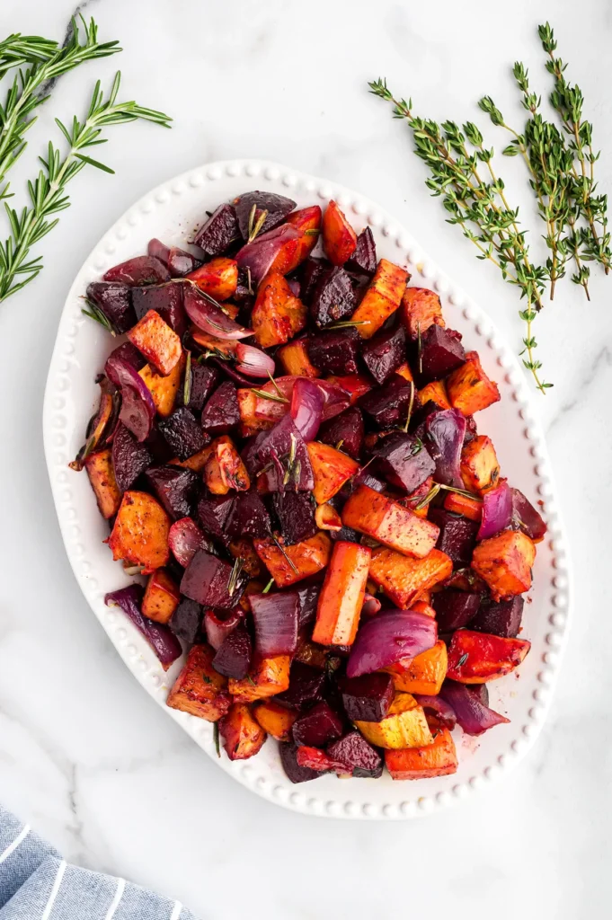 root vegetables on white plate with fresh herbs 