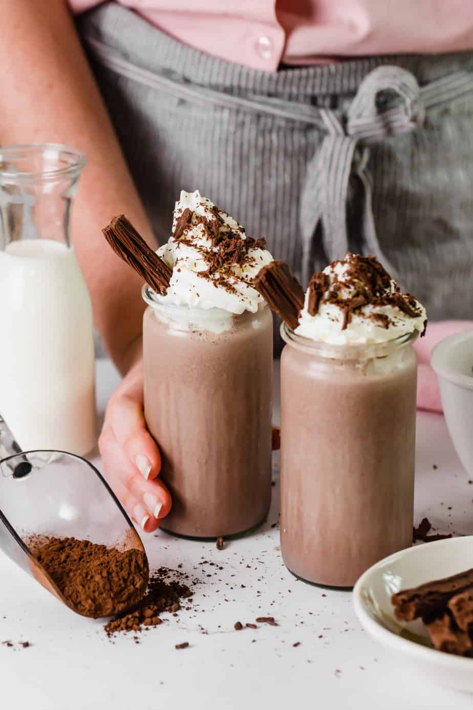 Two chocolate brownie milkshakes with whipped cream and chocolate.