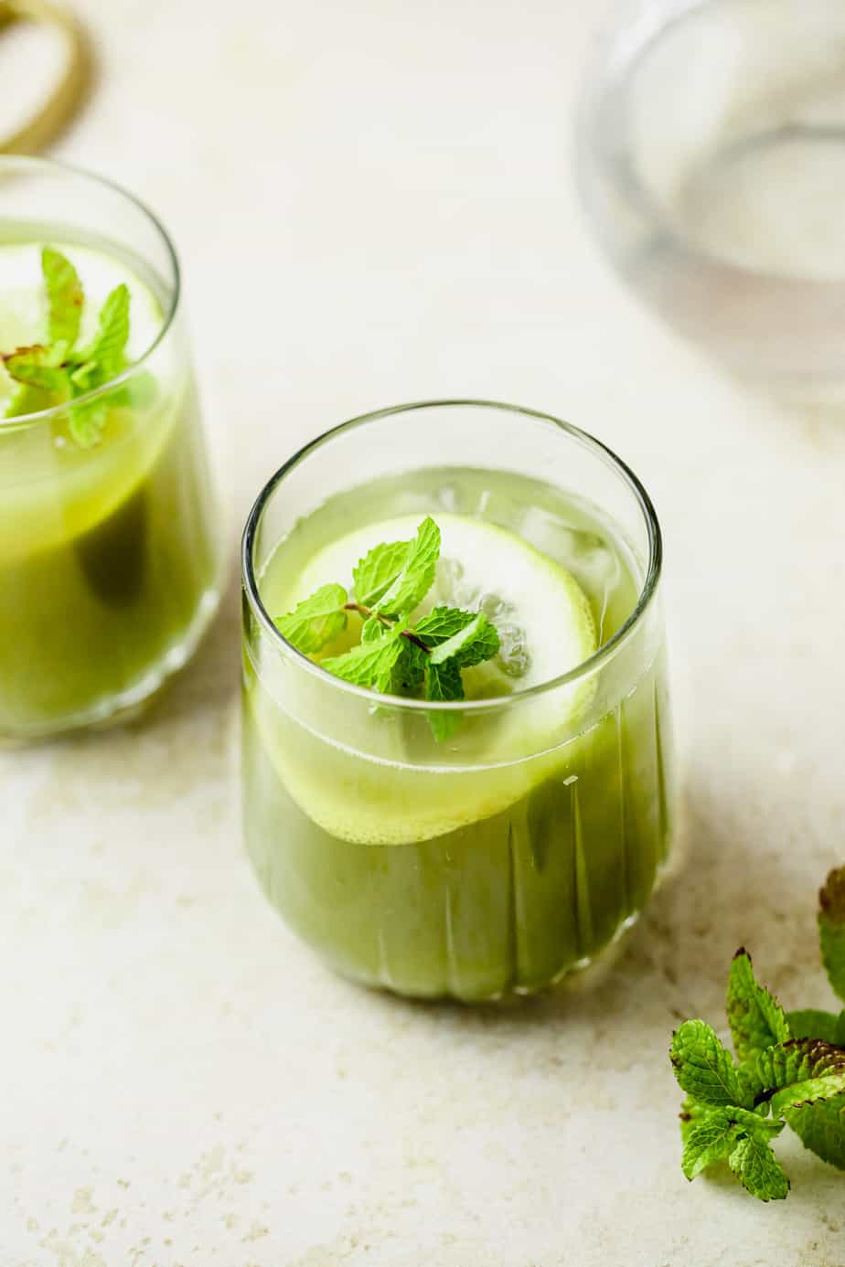 A of green matcha lemonade topped with fresh mint and a slice of lemon.