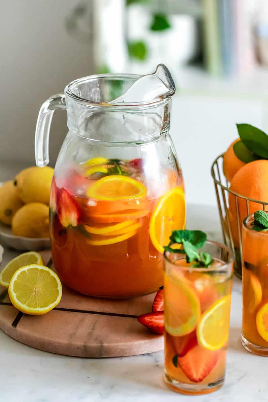 A pitcher with juice and fresh fruit.