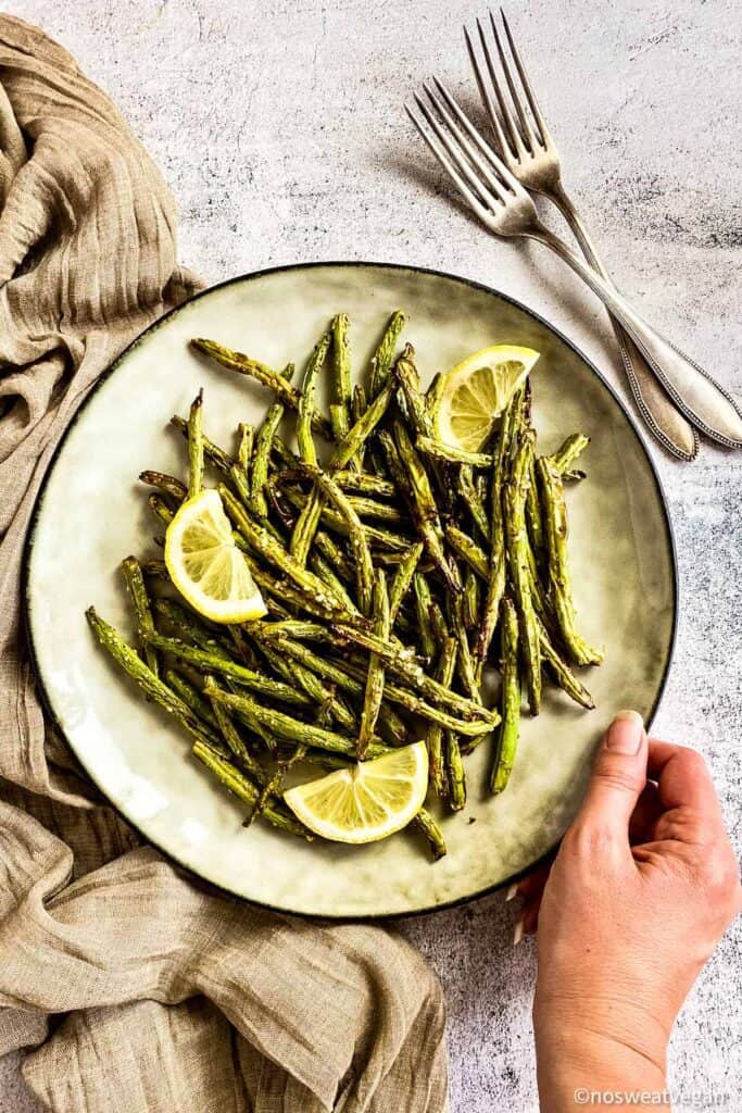 air fryer green beans on plate with lemons