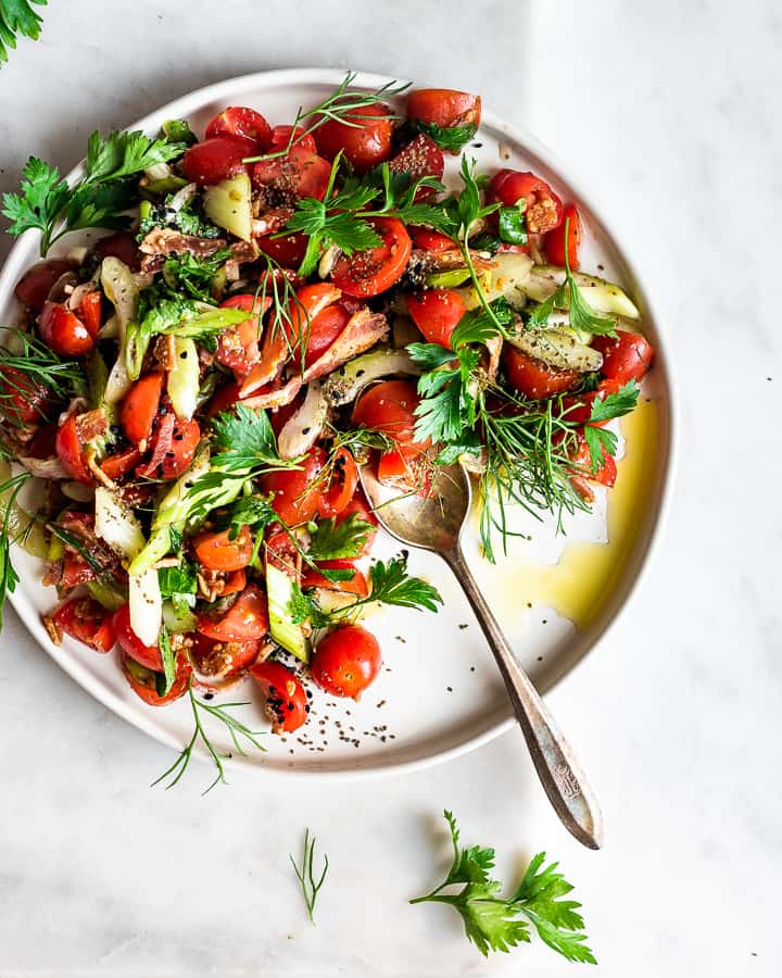 cherry tomato salad with fresh herbs on marble background