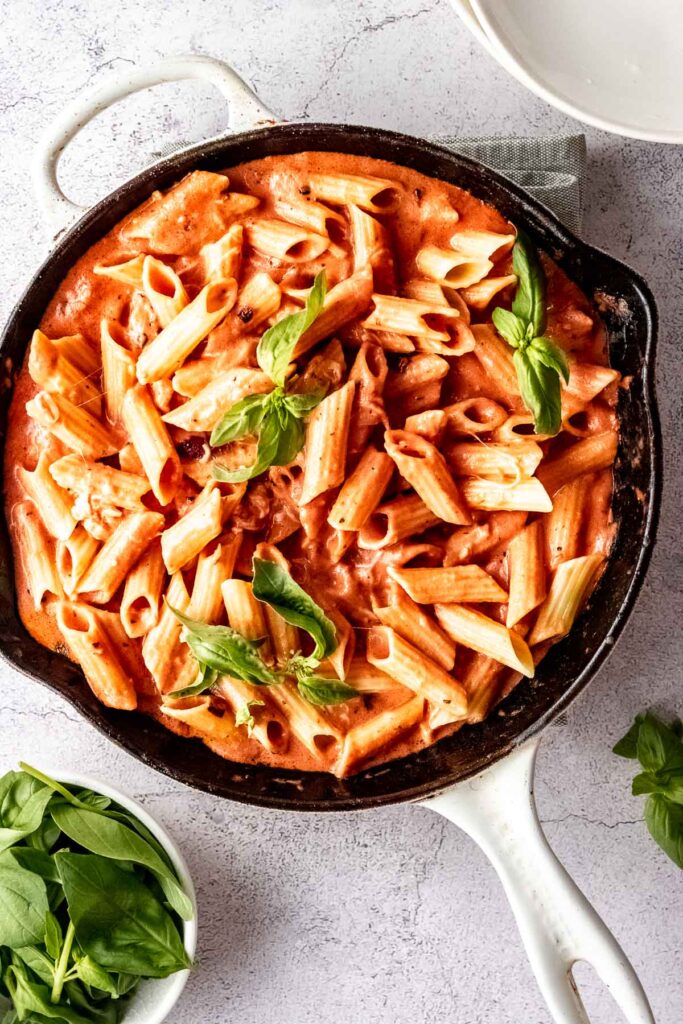 tomato pasta with fresh basil in white skillet