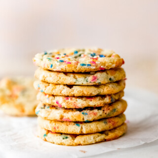 A stack of vegan funfetti cookies sitting on a marble tray.