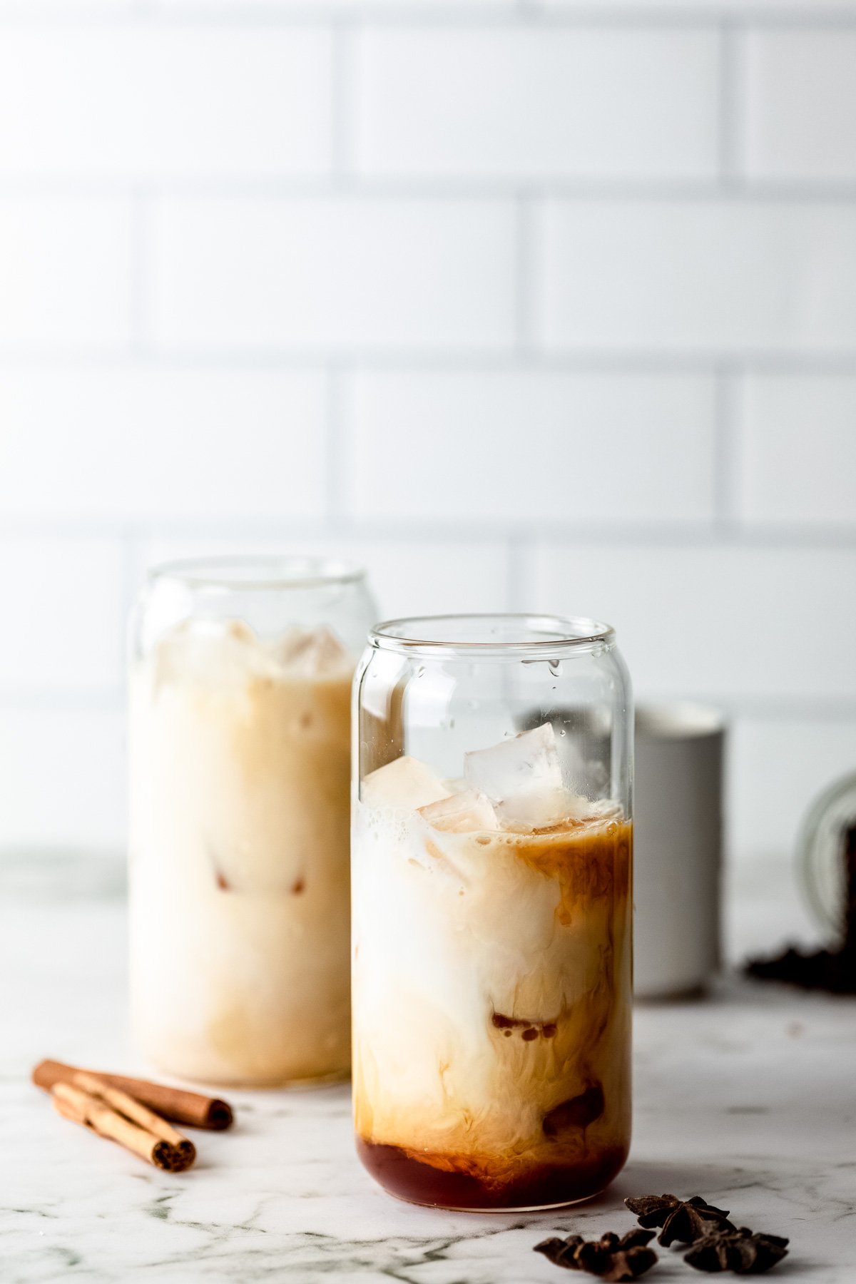 An iced chai latte in a serving glass before being mixed together. 