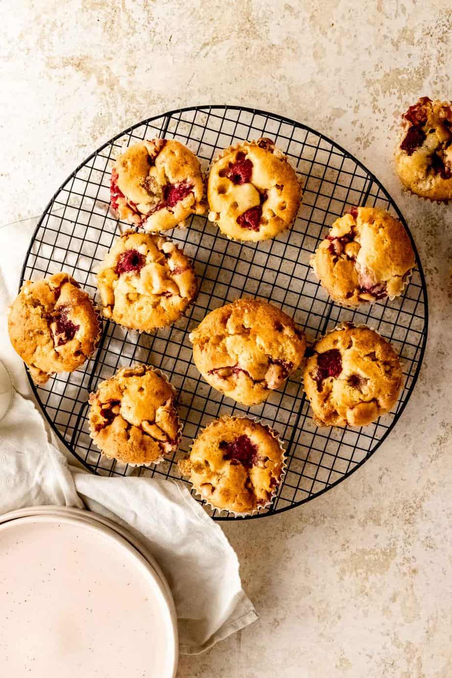 White chocolate and raspberry muffins on a cooling rack.