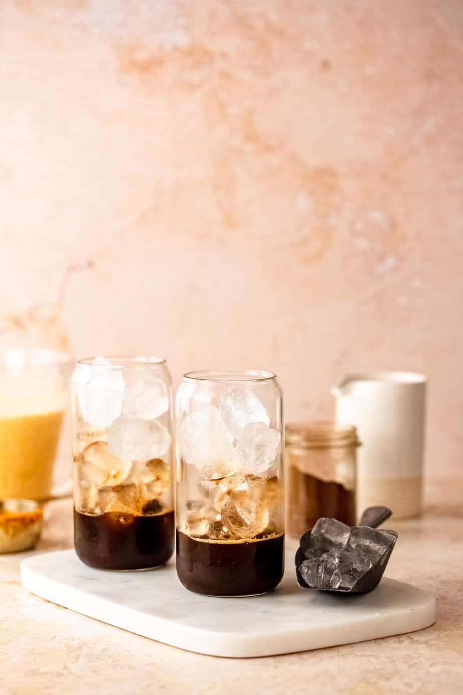 A glass filled with ice cubes and a shot of espresso.