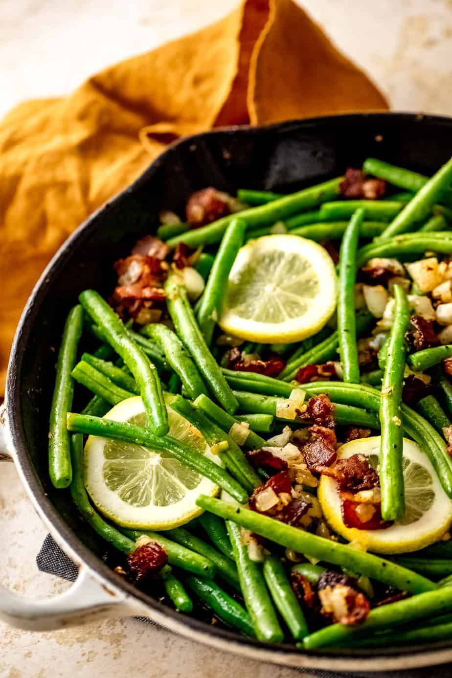 A close up of crack green beans in a skillet.