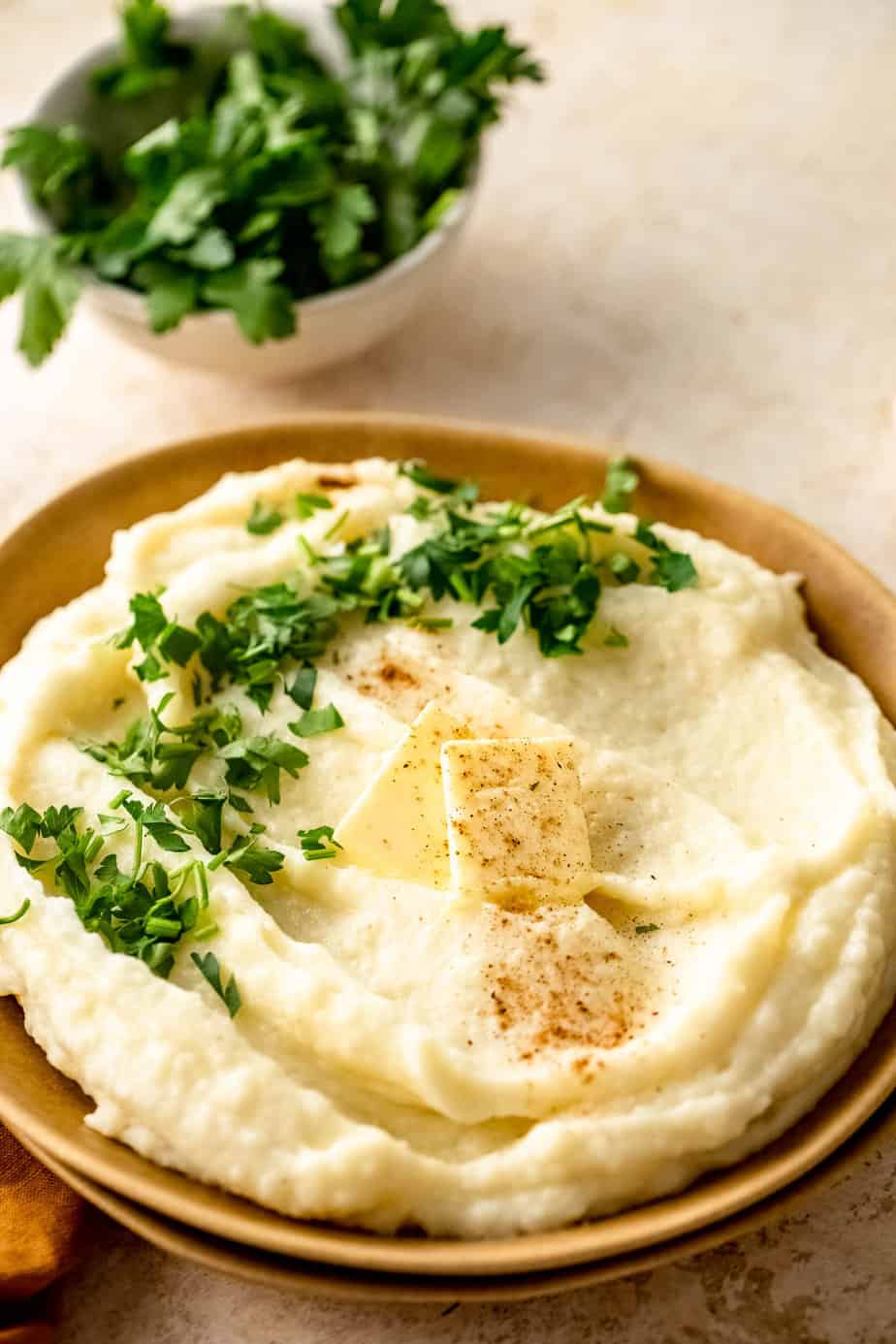 A bowl of mash with fresh herbs and butter.