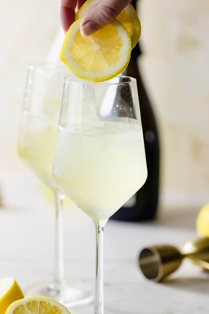 two lemon slices and two wine glasses with limoncello spritz