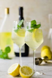 wine glasses filled with limoncello spritz and fresh mint sprigs